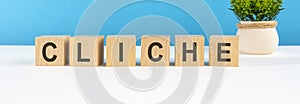 CLICHE word made with wooden blocks on white desk, blue background