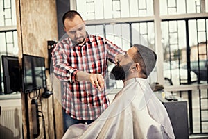 Client during beard and moustache grooming in barber