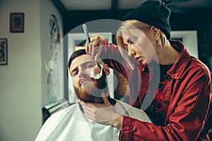 Client during beard shaving in barber shop