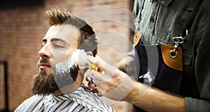 Client during beard shaving in barber shop