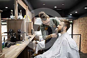 Client during beard shaving in barber shop