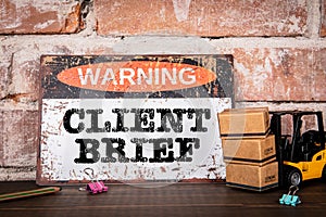 CLIENT BRIEF. Warning sign with text on wooden office desk