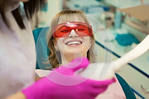 The client at the dentist`s office in the office smiles