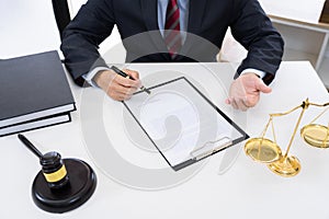 Client with his partner lawyers or attorneys discussing discussing a document or contract agreement working at table in office,