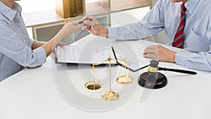 Client with his partner lawyers or attorneys discussing discussing a document or contract agreement working at table in office,