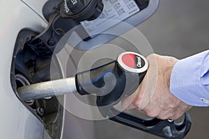 client holding diesel pump hose hooked to the car's fuel tank with his hand
