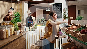 Client placing vegetables in paper bag