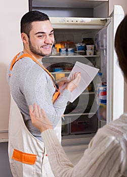 Client and repairman near fridge