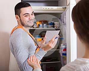 Client and repairman near fridge