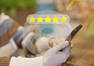 Client use smartphone give rating to service experience on the online application, and evaluate the quality reputation five star.
