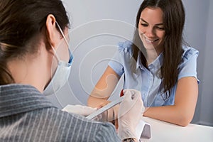 Client woman on manicure in beauty salon, manicurist is polishing her nails.