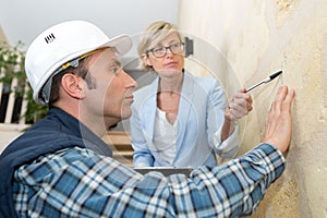 cliente and mason worker checking finishing wall photo