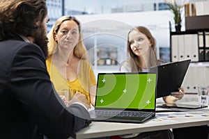 Clients checking investment plan on chroma key laptop photo