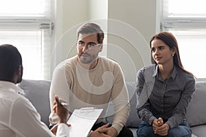 Clients couple talk consulting with male psychologist at meeting