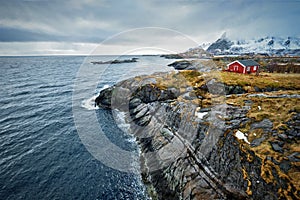 Clif with traditional red rorbu house on Lofoten Islands, Norway