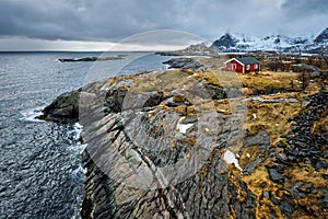 Clif with traditional red rorbu house on Lofoten Islands, Norway