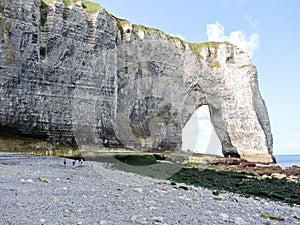 Cliff with arch on pebble beach of Etretat