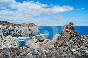 Stacked cliff volcanic rocks next to the turquoise sea in Alagoa da FajÃÂ£zinha, Terceira - Azores PORTUGAL photo