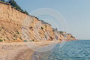 Cliff of clay and sand on the sea beach, the danger of collapse