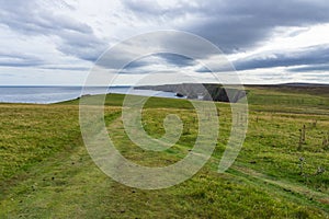 Cliff coastline with sea stacks at Duncansby Head, Caithness, Scotland on a cloudy day