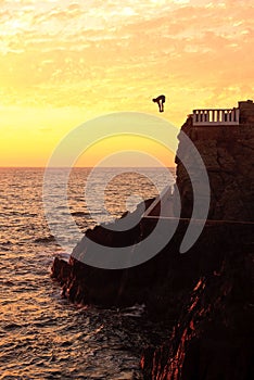 Cliff diver off the coast of Mazatlan at sunset