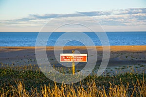 Cliff edge warning sign beach and sand dunes at Lowestoft Suffolk