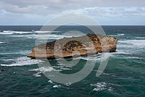 A cliff in the middle of the sea washed by the waves on the Great Ocean Road in Australia