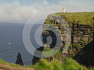 Cliff of Moher, O`Brien`s Tower and Atlantic ocean, warm sunny day, Cloudy sky. County Clare Ireland