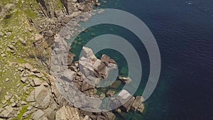 Cliff mountain and blue sea aerial view. Beautiful rocky coast and transparent ocean water view from flying drone. Top