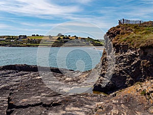 A cliff on the Ocean in Ireland on a sunny summer day. Irish seaside landscape, clear blue sky, rock formation near body of water