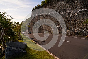 The cliff overhangs along the road to the ocean at sunset