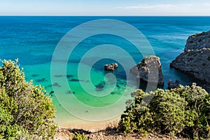 Cliff at Ribeiro do Cavalo beach, with clear water and rocks, Sesimbra PORTUGAL