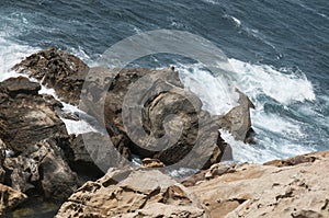 Cliff with rocks in the background and waves beating against them