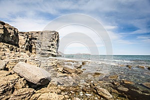 Cliff on spring time with the deep blue sea and sky with clouds