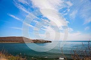 Cliff on spring time with the deep blue sea and sky with clouds