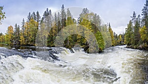 Cliff, stone wall, forest, waterfall and wild river panoramic view in autumn. Fall colors - ruska time in Myllykoski.