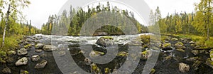 Cliff, stone wall, forest, waterfall and wild river panoramic view in autumn. Fall colors - ruska time