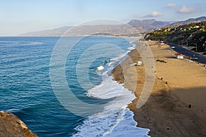 Cliff top view of california beach shoreline waves breaking into distance