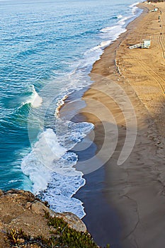 Cliff top view of california beach shoreline waves breaking into distance