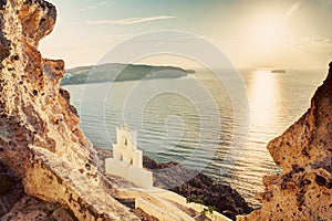 Cliff, volcanic rocks and a traditional chapel on Santorini island, Greece