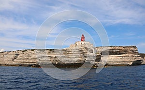 cliffed coast and a red lighthouse near Bonifacio Town in Corsic photo