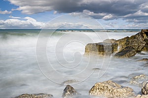 Cliffs in Adriatic sea. The sun's rays reflecting on the rocks. Long exposure.