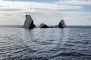 The cliffs of Cyclops Faraglioni dei Ciclopi in sea near Aci Trezza town, Sicily, Italy. Large stones are believed to be thrown