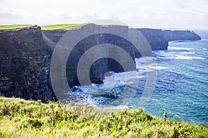 Cliffs of Moher at Alantic Ocean in Western Ireland with waves battering against the rocks