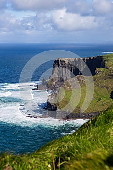 Cliffs of Moher at Alantic Ocean in Western Ireland with waves battering against the rocks photo