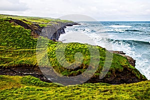 Cliffs of Moher at the Alantic Ocean in Western Ireland with waves battering against the rocks