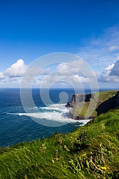 Cliffs of Moher at Alantic Ocean in Western Ireland with waves battering against the rocks