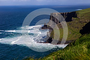 Cliffs of Moher at Alantic Ocean in Western Ireland with waves battering against the rocks