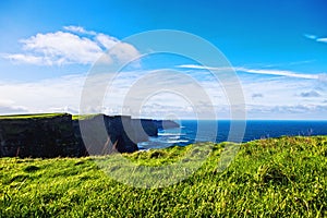 Cliffs of Moher at Alantic Ocean in Western Ireland with waves battering against the rocks photo