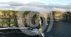 Cliffs of Moher shrouded in low clouds on a sunset 4k